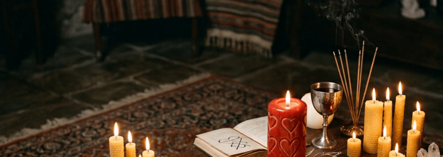 Woman reading a parchment during a witchcraft ritual with candles and mystical symbols on table